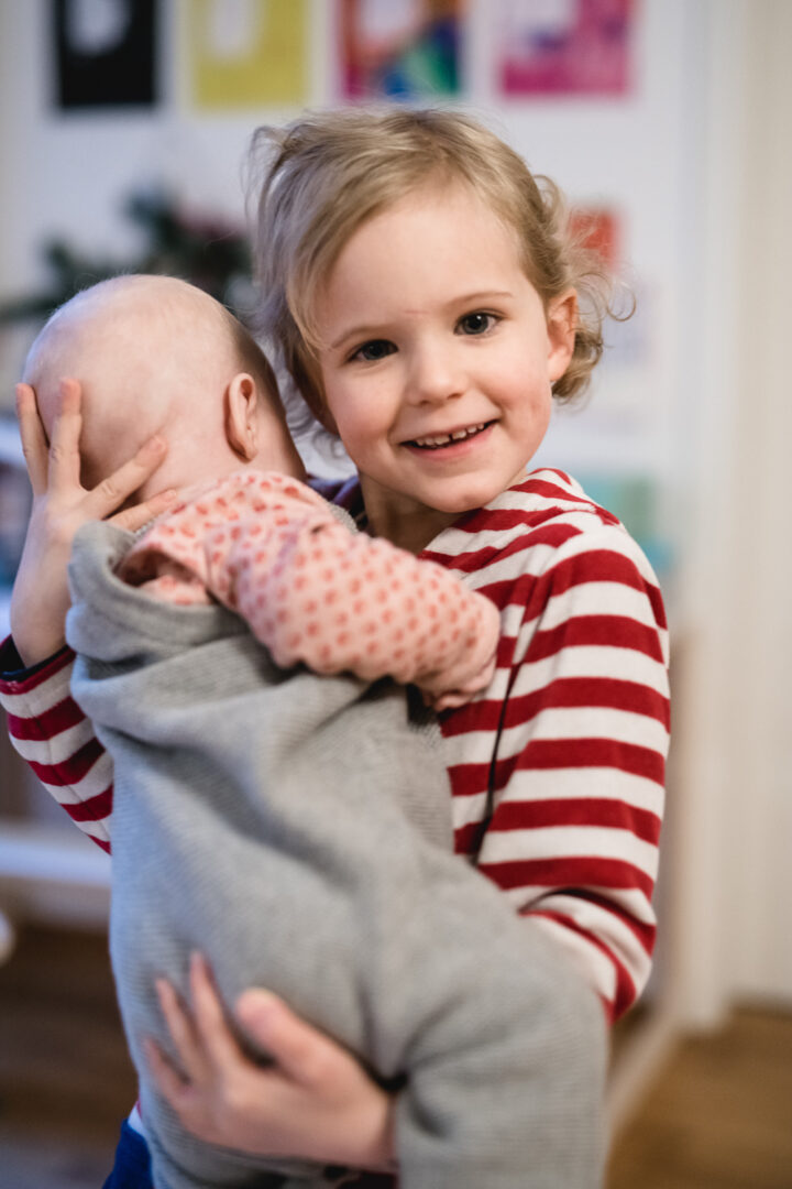 Baby mit stolzer großer Schwester - Neugeborenen Fotos natürlich