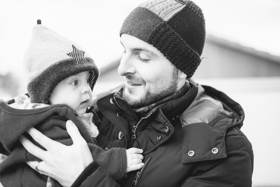 Papa und Sohn mit Mütze im Winter